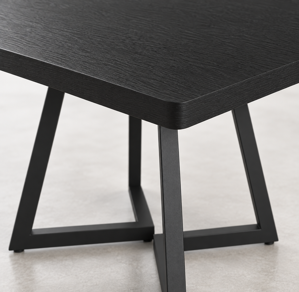 Détail du plateau noir effet bois et des pieds métal de la table carrée