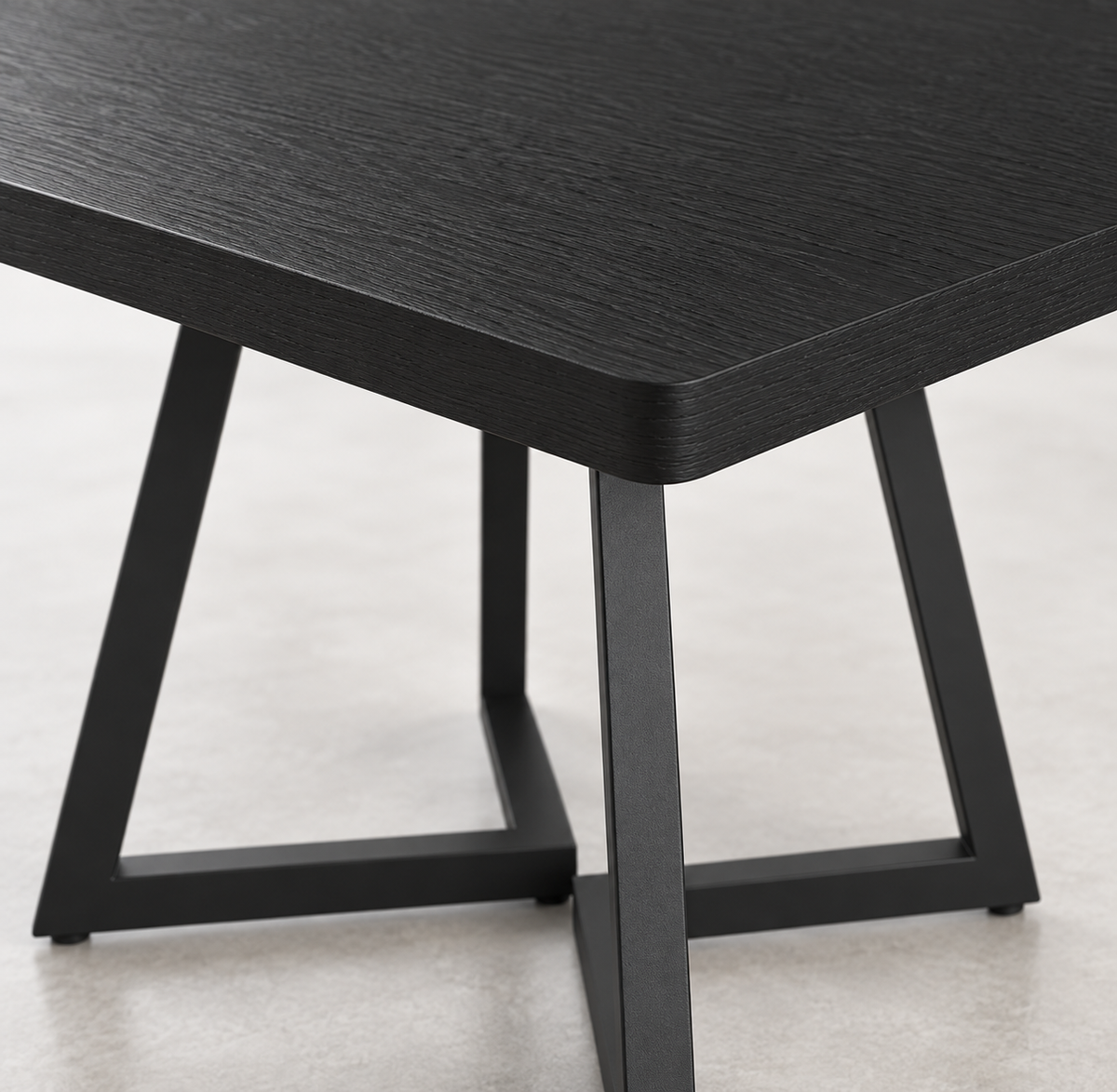 Détail du plateau noir effet bois et des pieds métal de la table carrée